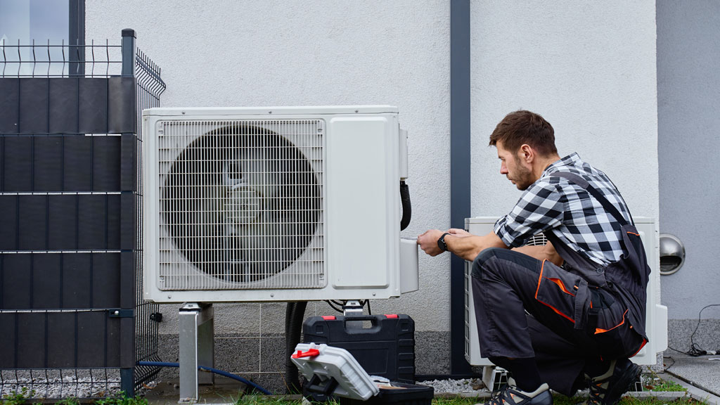 Expert CVC effectuant une maintenance préventive sur thermopompe commerciale